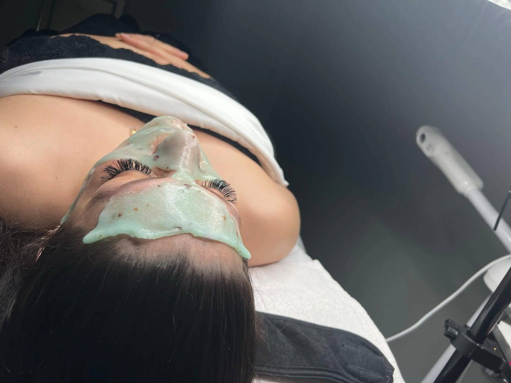 Client relaxing under a hydrating mask during a facial treatment