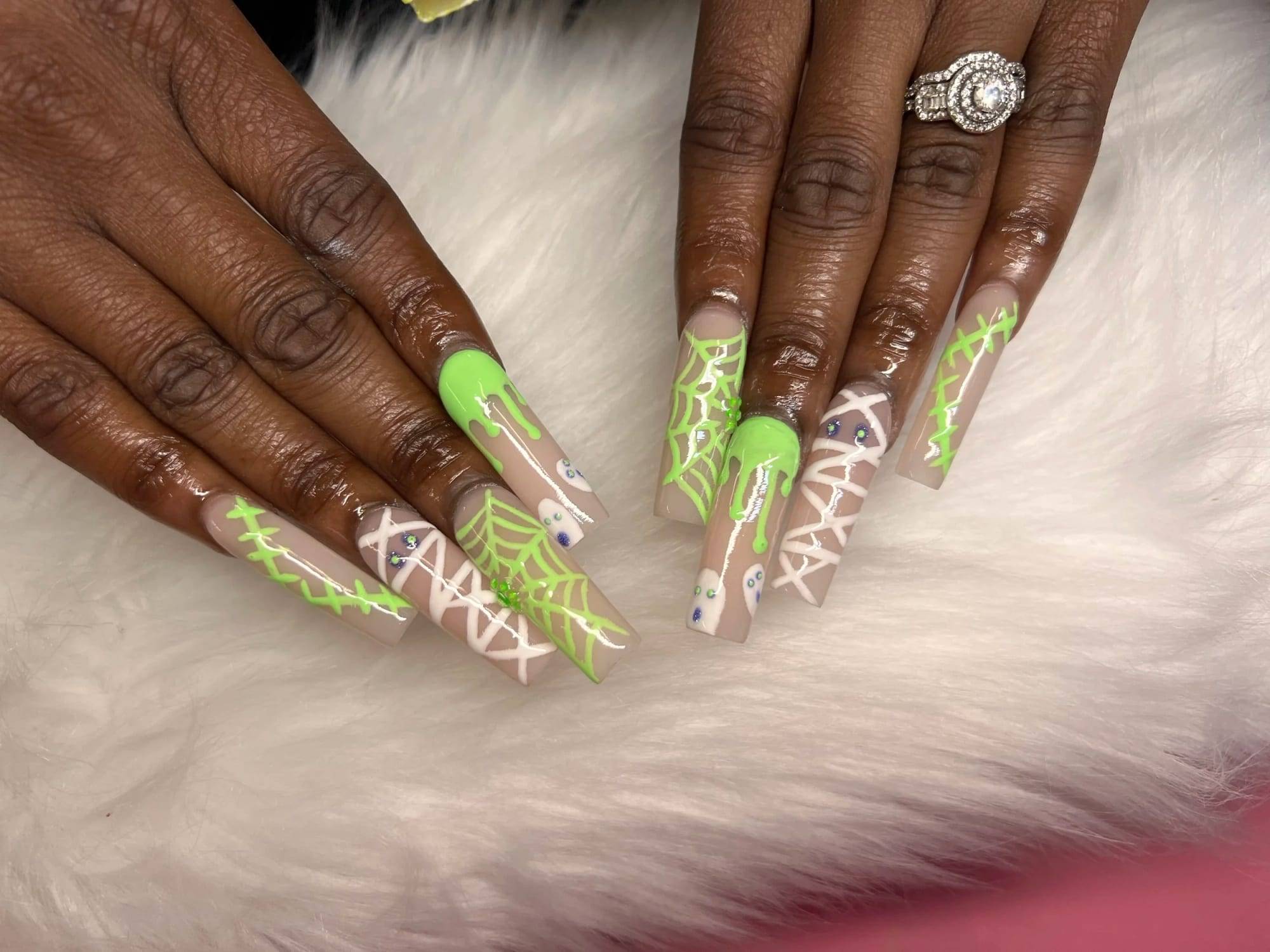 Long almond nails in neon green with white lettering on deep skin tone