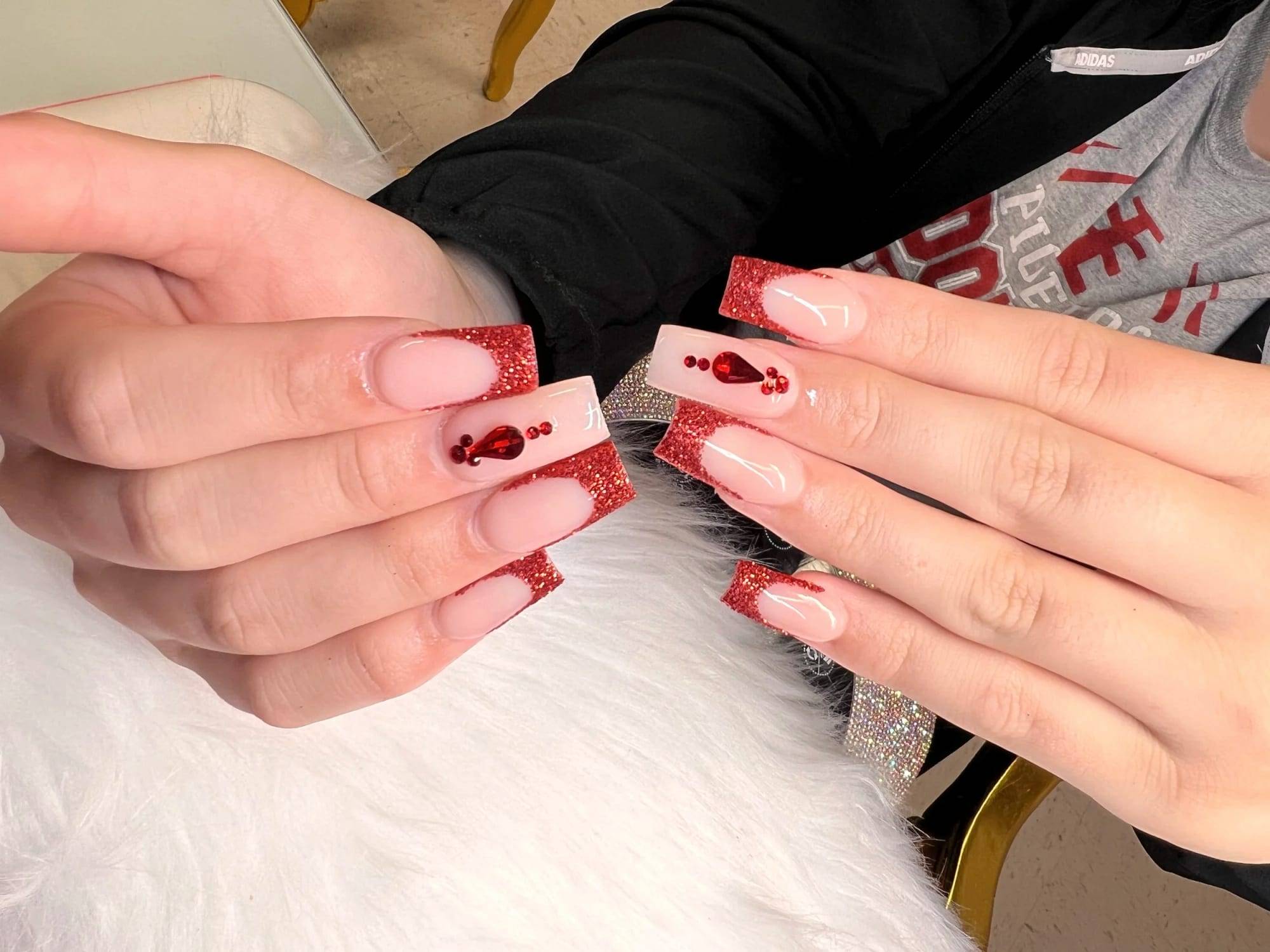 Nude square nails with red French tips and gem accents